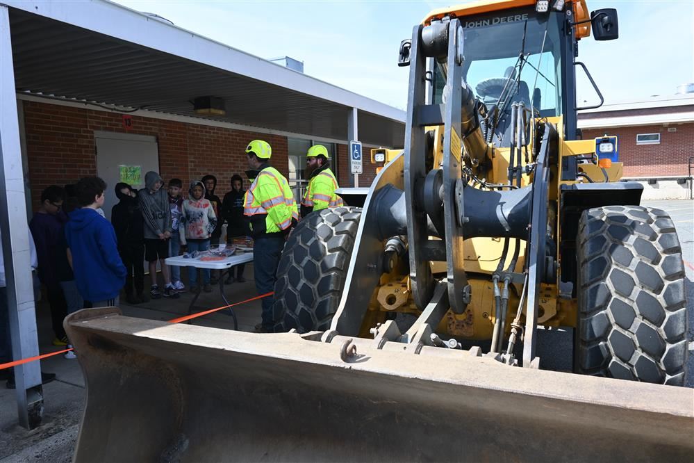  VDOT representatives speak to students outside the Wetsel Middle School cafeteria with a loader